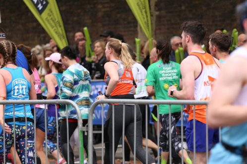 Runners behind metal barrier