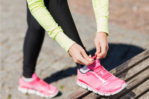 woman tying shoelace of trainers